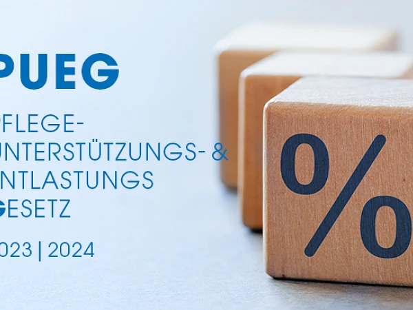 Holzblöcke mit einer Prozentsymbol und dem Text "PUEG Pflegeunterstützungs- & Entlastungsgesetz 2023 | 2024" im Hintergrund.