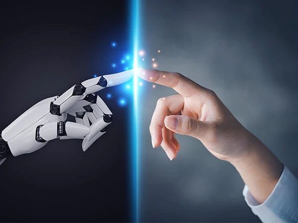 Eine menschliche Hand und eine Roboterhand nähern sich einander, während ein Lichtstrahl zwischen ihnen leuchtet und Funken sprüht.